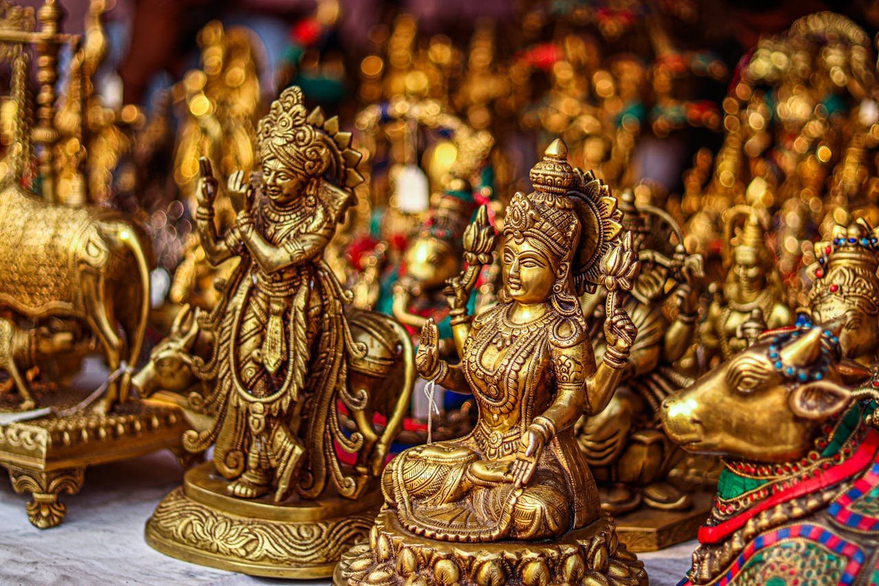 Close-up of elegant gold Hindu deity sculptures captured in intricate detail, embodying religious artistry.