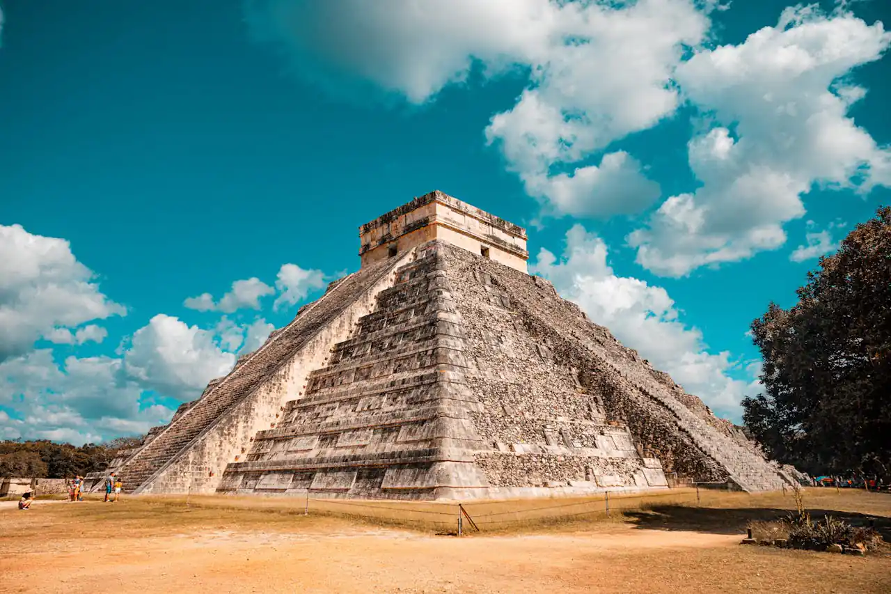 The iconic El Castillo pyramid at Chichen Itza, Mexico, captured on a sunny day with a vibrant blue sky.
